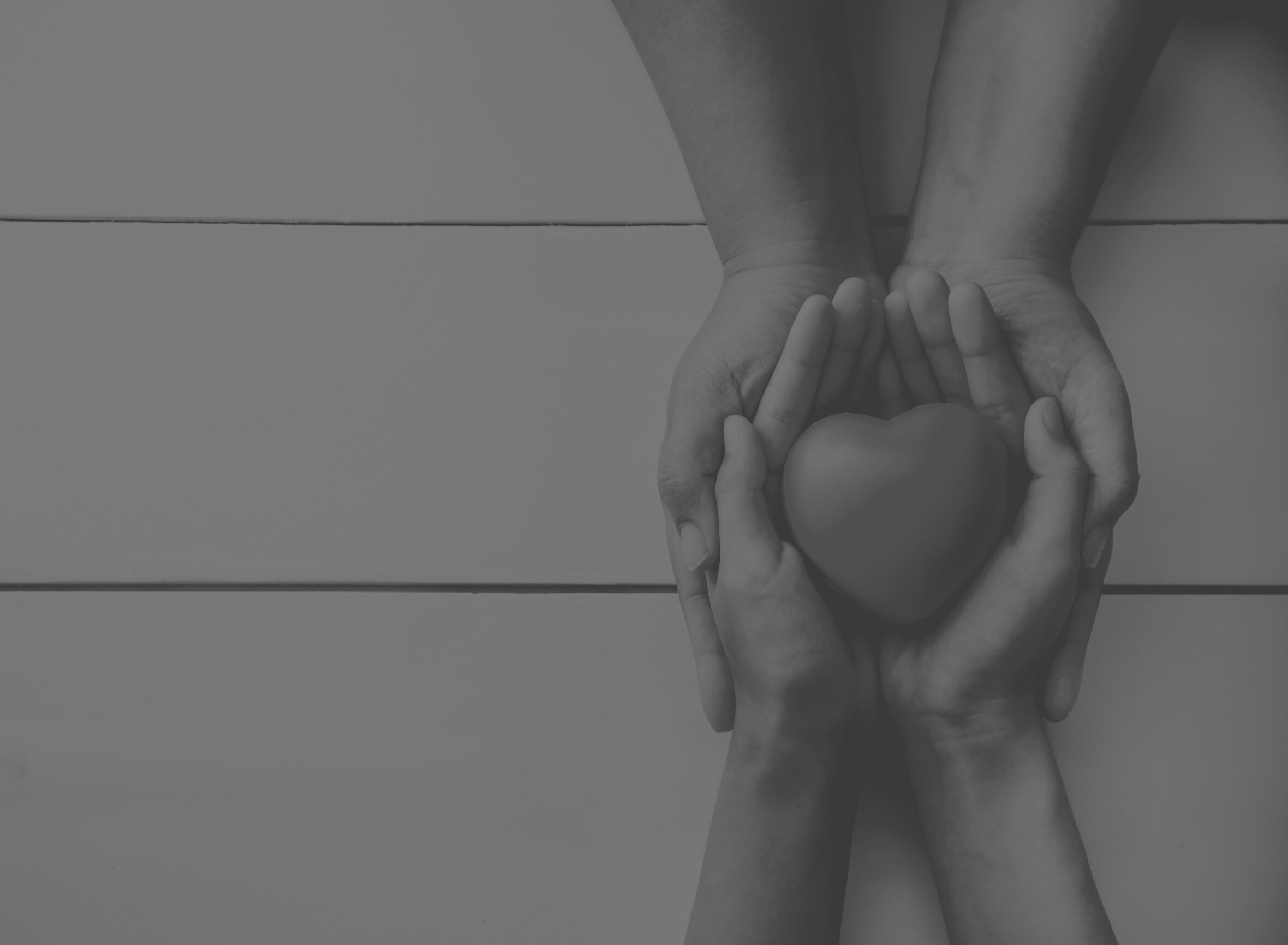 Adult Hand Holding a Child's Hand with a Red Heart